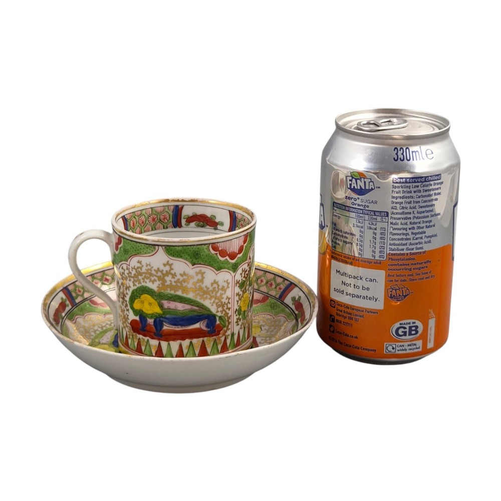 A Regency period Worcester porcelain coffee cup and matching saucer decorated in the hand-painted Dragon in Compartments pattern with green, red, blue, and gilt detailing. View XV