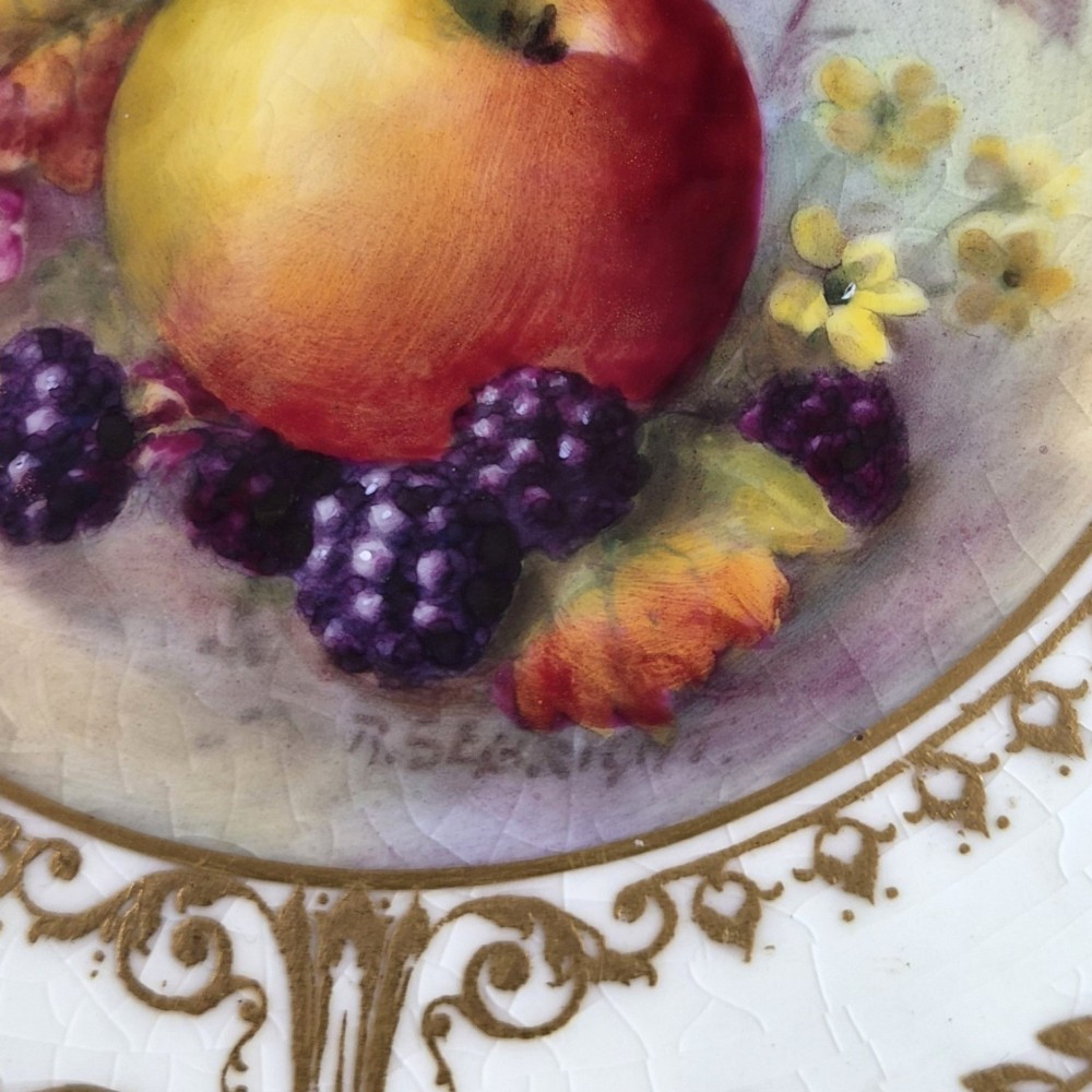 A circular Royal Worcester porcelain cabinet plate featuring a cobalt blue rim with detailed gold gilding framing a central painted still life of apples and berries. View II