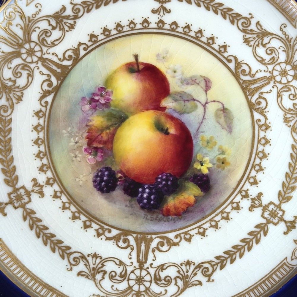 A circular Royal Worcester porcelain cabinet plate featuring a cobalt blue rim with detailed gold gilding framing a central painted still life of apples and berries. View III