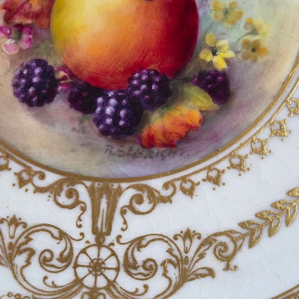 A circular Royal Worcester porcelain cabinet plate featuring a cobalt blue rim with detailed gold gilding framing a central painted still life of apples and berries. View XI