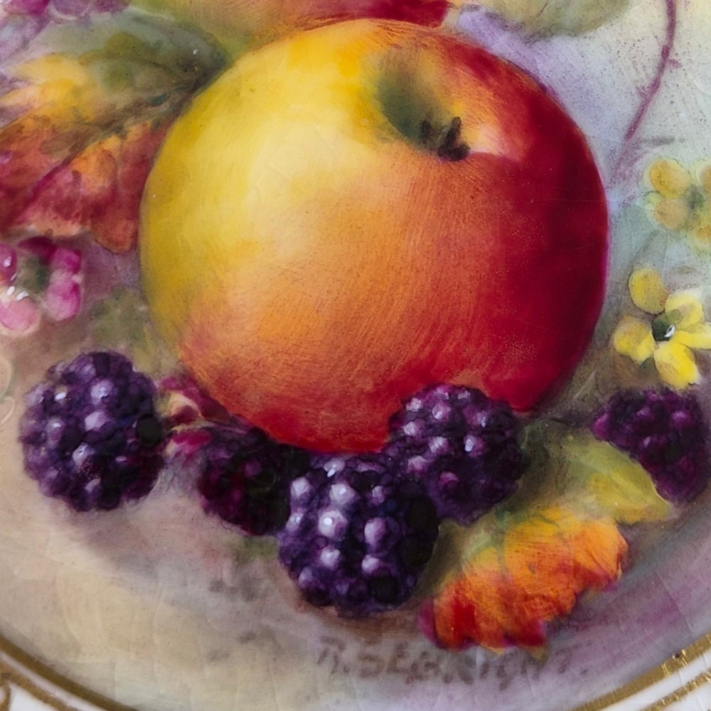 A circular Royal Worcester porcelain cabinet plate featuring a cobalt blue rim with detailed gold gilding framing a central painted still life of apples and berries. View XII