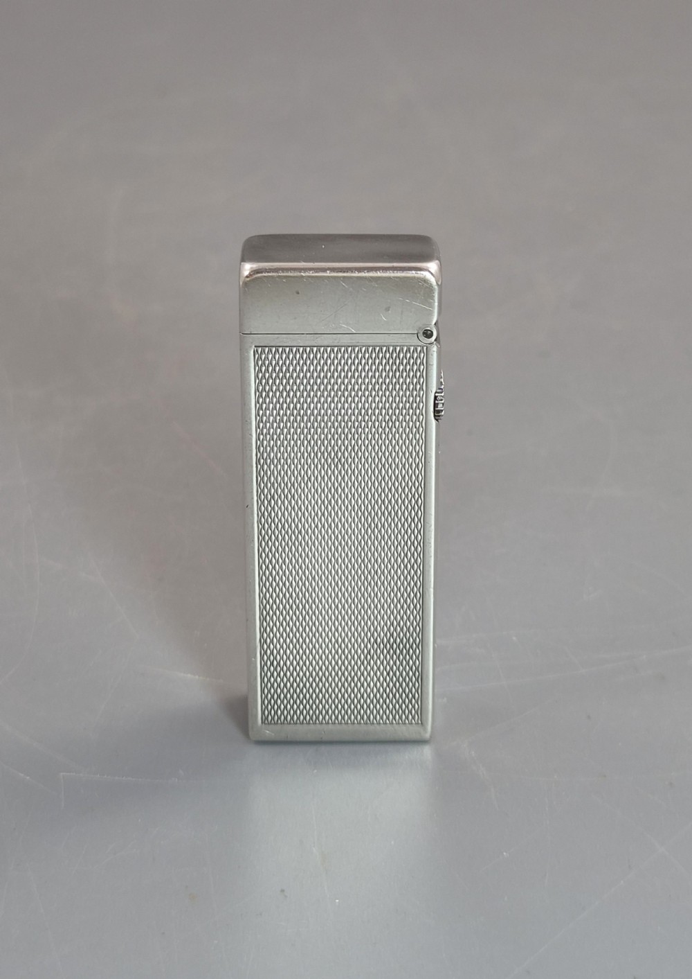 A silver-toned Dunhill Rollagas lighter shown alongside its original paper instruction booklet and red leatherette presentation case. View III