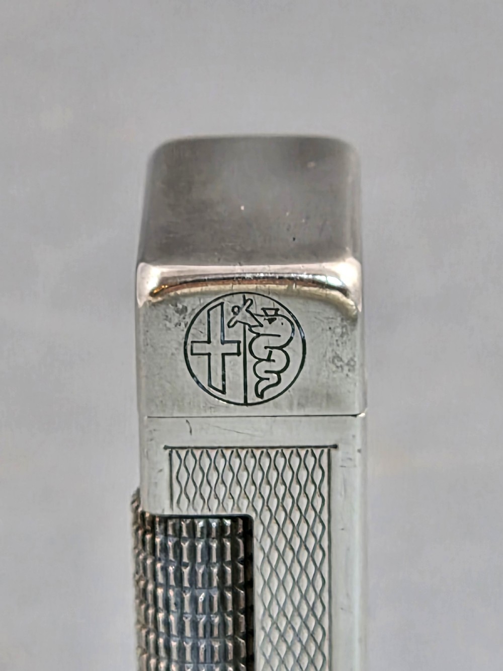 A silver-toned Dunhill Rollagas lighter shown alongside its original paper instruction booklet and red leatherette presentation case. View VII