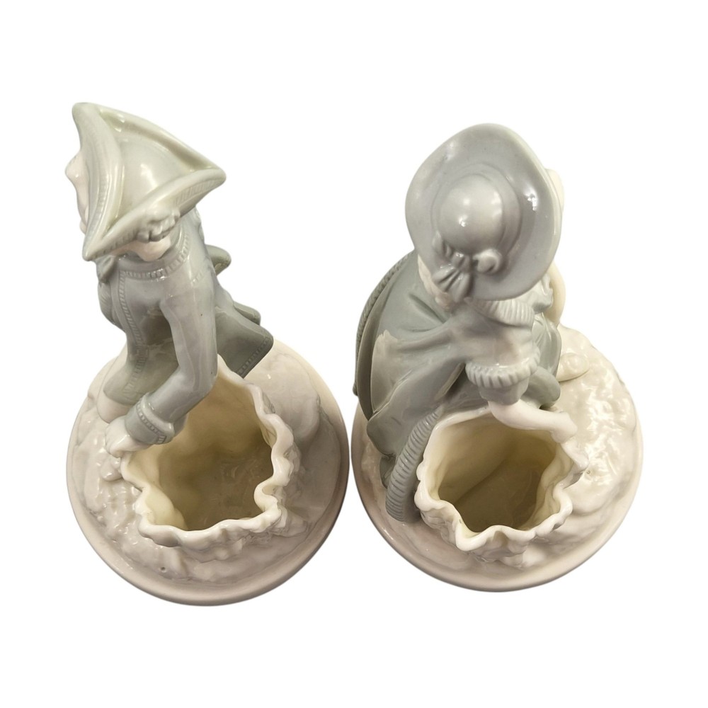 A pair of late Victorian grey and cream glazed porcelain figural salts depicting a man and woman beside hollow tree stump vessels. View VI