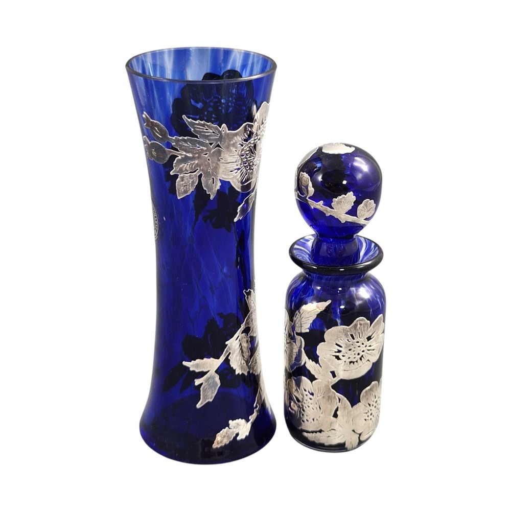 A cobalt blue glass vase and matching perfume bottle with stopper, both featuring intricate sterling silver floral overlay. View IV