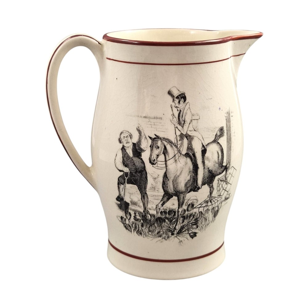 A Georgian creamware jug featuring a black transfer-printed hunting scene and terracotta red painted rim accents against a cream glaze. View IV