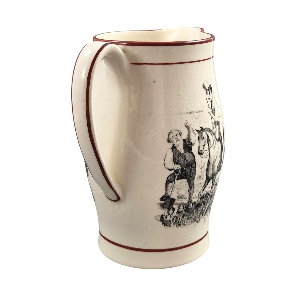 A Georgian creamware jug featuring a black transfer-printed hunting scene and terracotta red painted rim accents against a cream glaze. View V