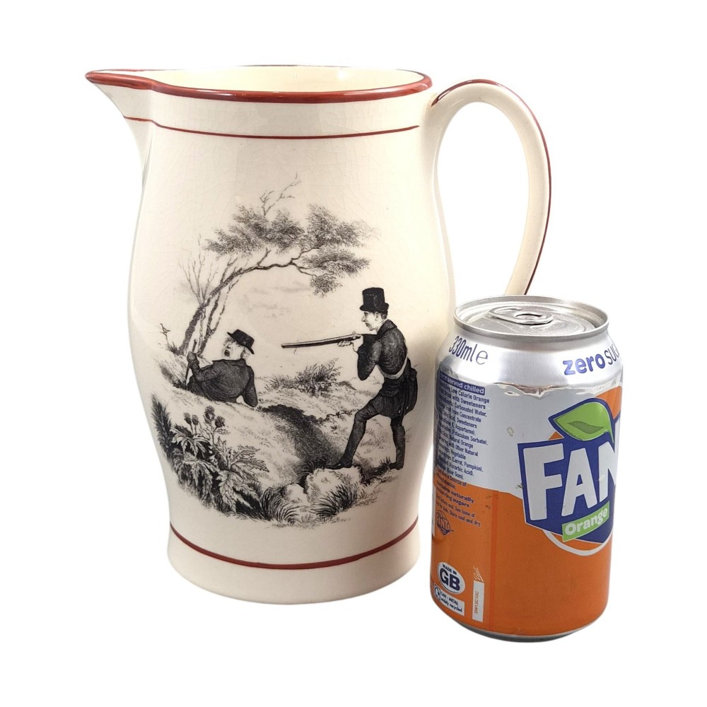 A Georgian creamware jug featuring a black transfer-printed hunting scene and terracotta red painted rim accents against a cream glaze. View IX