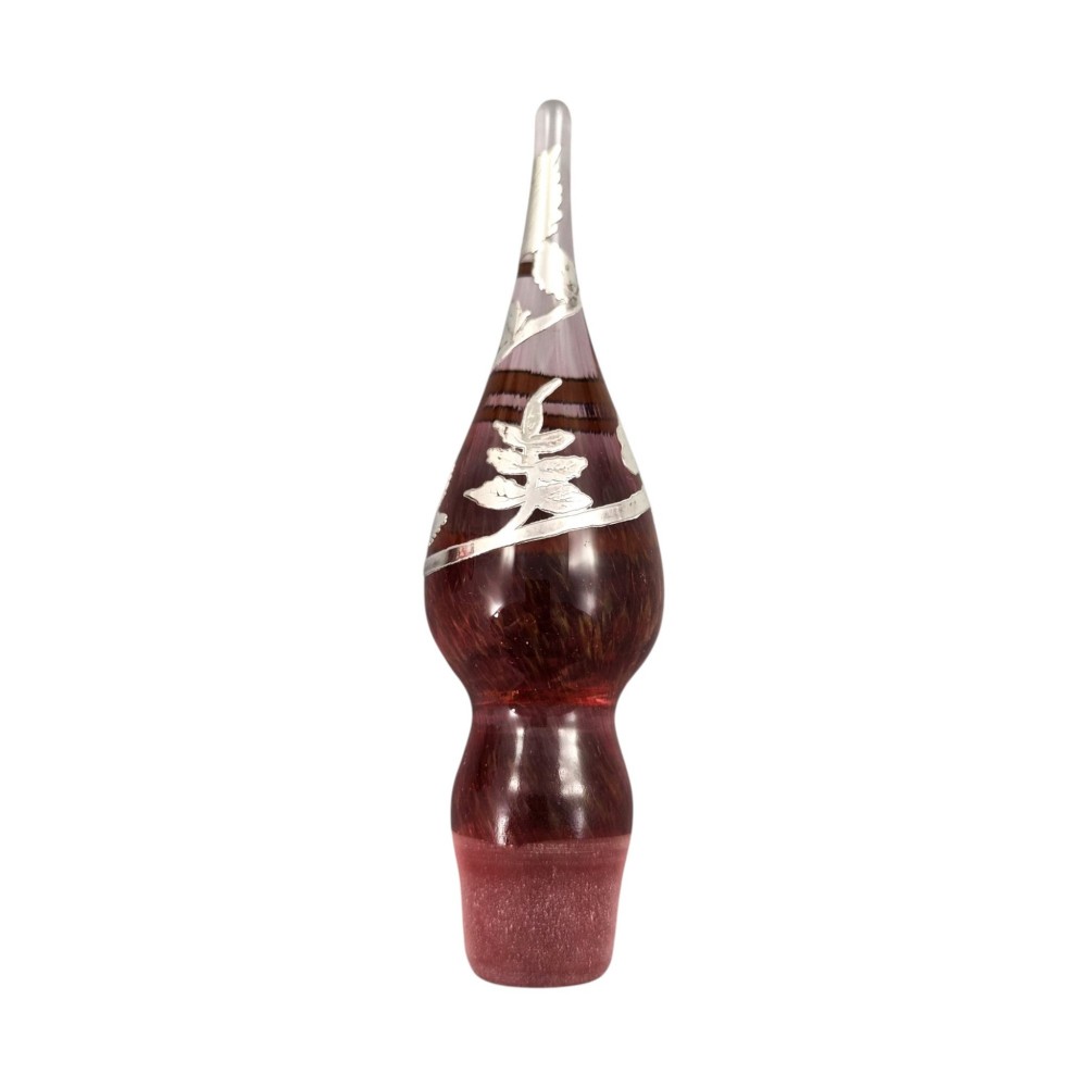 A three-piece ruby red glass vanity set featuring floral sterling silver overlay details across two stoppered bottles and a cylindrical beaker. View VI