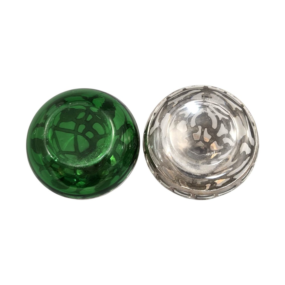 A pair of Art Nouveau perfume bottles featuring detailed sterling silver overlay in intricate floral lattice patterns on green and clear glass bases with matching glass stoppers. View VII