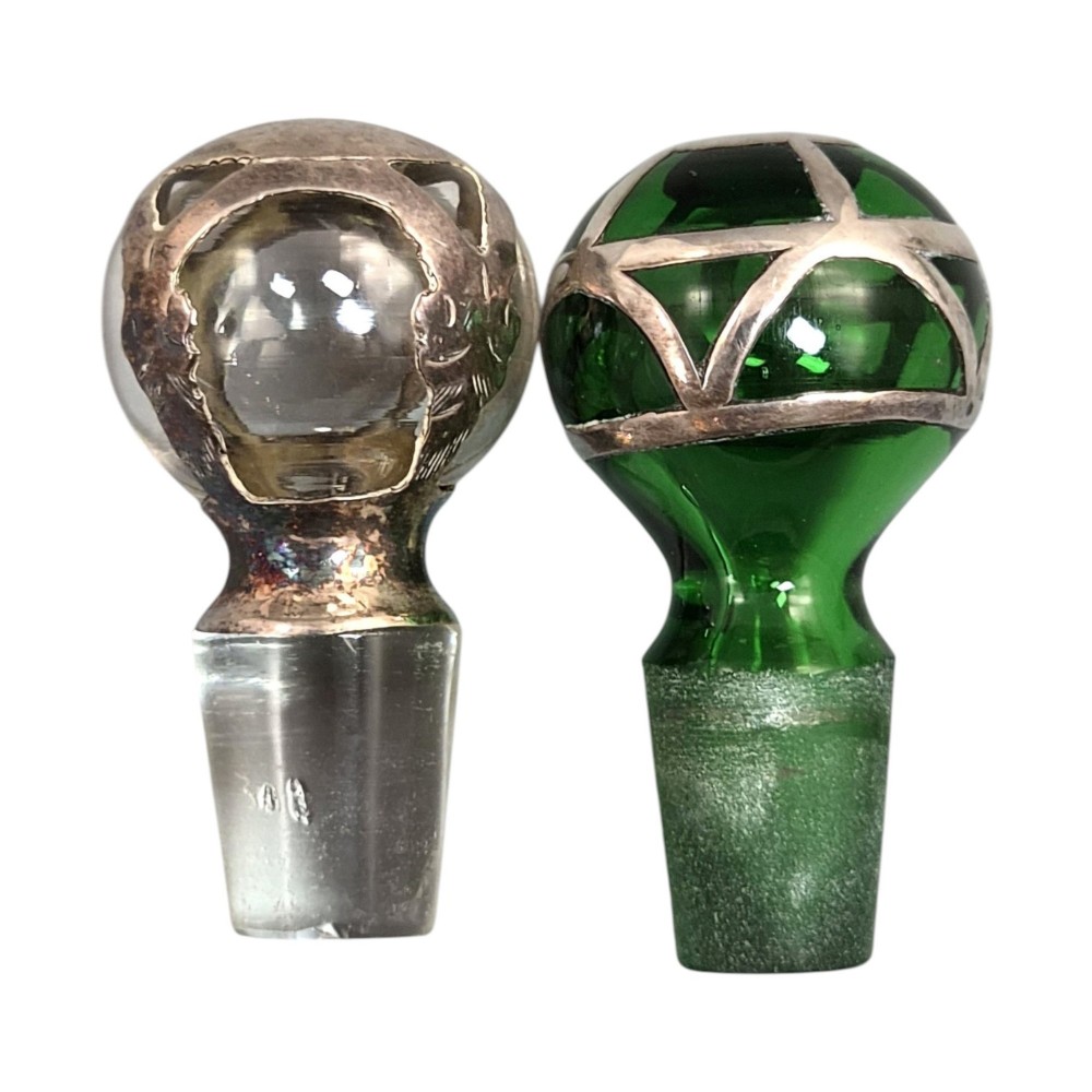 A pair of Art Nouveau perfume bottles featuring detailed sterling silver overlay in intricate floral lattice patterns on green and clear glass bases with matching glass stoppers. View VIII
