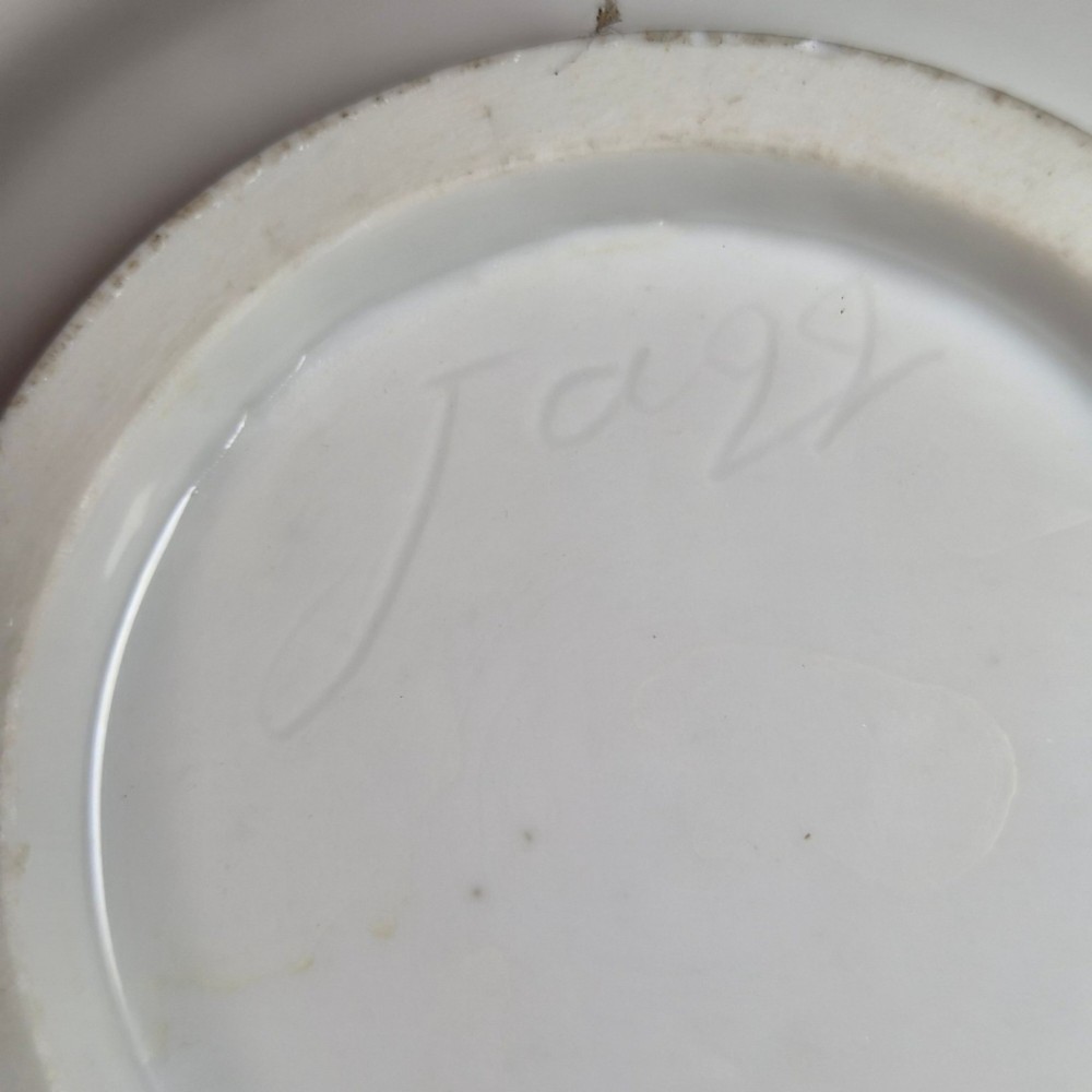 A red and gilded French Empire porcelain cabinet cup and matching saucer featuring a raised white lion mask handle detail. View V
