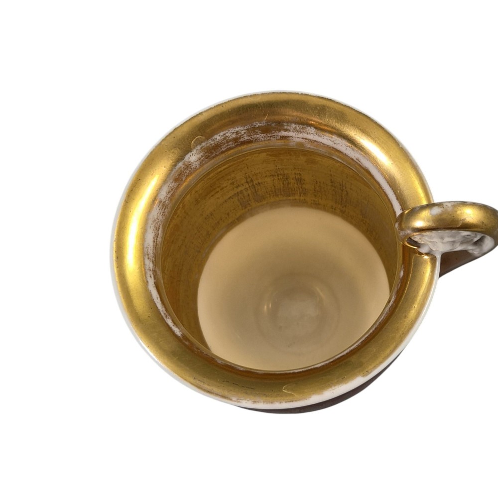 A red and gilded French Empire porcelain cabinet cup and matching saucer featuring a raised white lion mask handle detail. View XI