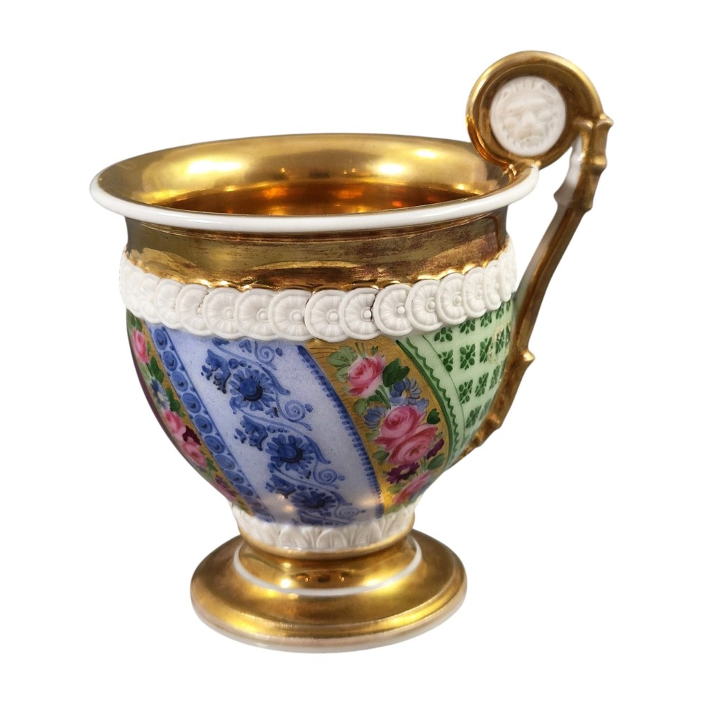 A nineteenth-century French Vieux Paris porcelain cabinet cup and matching saucer featuring gold gilding, multi-coloured hand-painted panels, and a high-loop lion mask handle. View VIII
