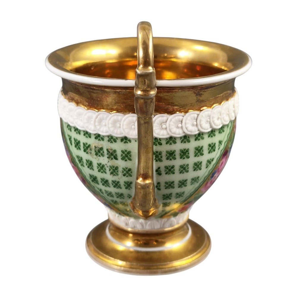 A nineteenth-century French Vieux Paris porcelain cabinet cup and matching saucer featuring gold gilding, multi-coloured hand-painted panels, and a high-loop lion mask handle. View IX