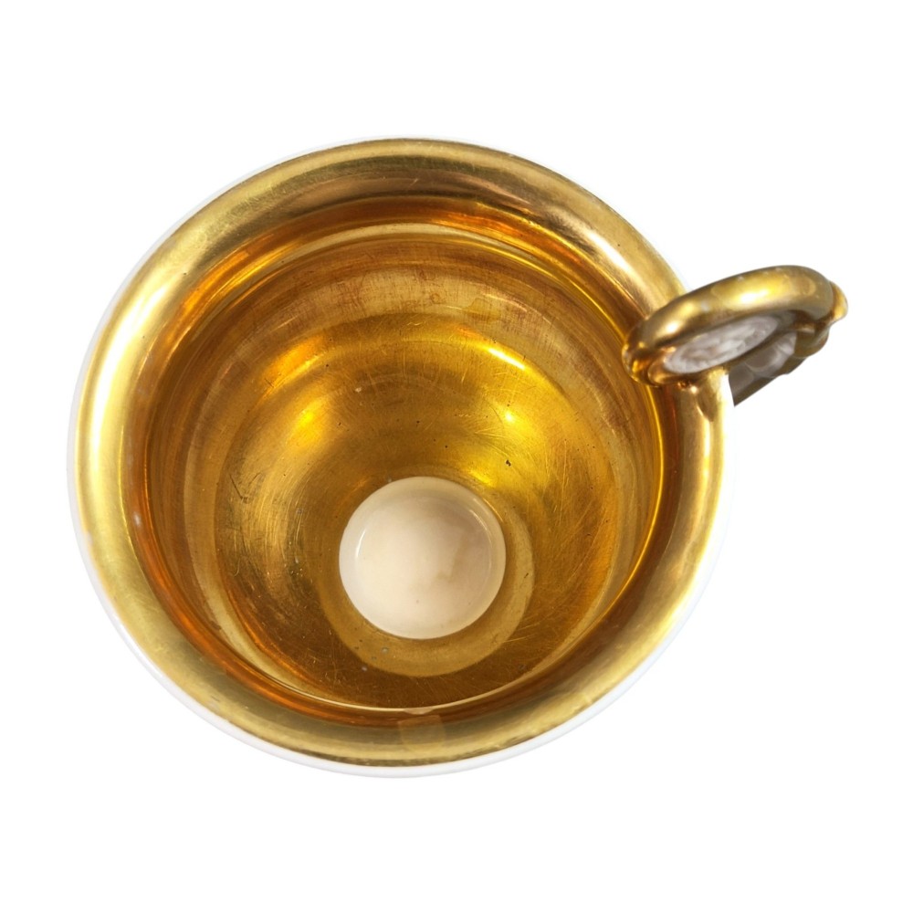 A nineteenth-century French Vieux Paris porcelain cabinet cup and matching saucer featuring gold gilding, multi-coloured hand-painted panels, and a high-loop lion mask handle. View XII