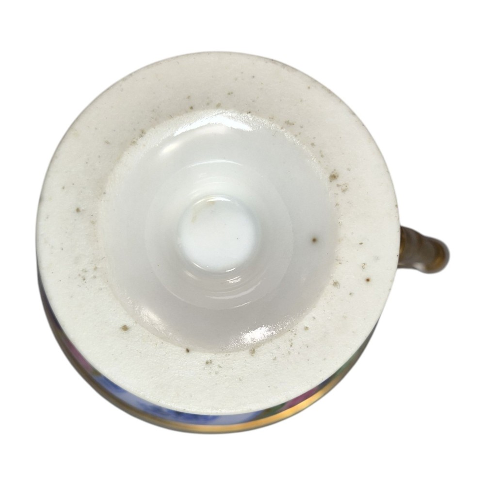 A nineteenth-century French Vieux Paris porcelain cabinet cup and matching saucer featuring gold gilding, multi-coloured hand-painted panels, and a high-loop lion mask handle. View XIII