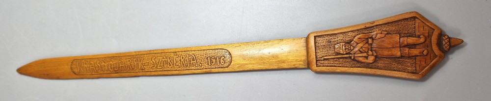 A hand-carved wooden letter opener featuring a relief carving of a soldier on the handle and carved text reading Krasnojarsk Sziberia 1916 on the blade. View II