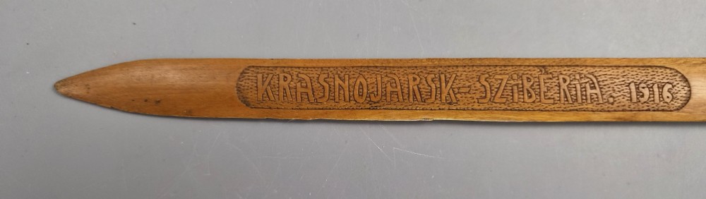 A hand-carved wooden letter opener featuring a relief carving of a soldier on the handle and carved text reading Krasnojarsk Sziberia 1916 on the blade. View VI