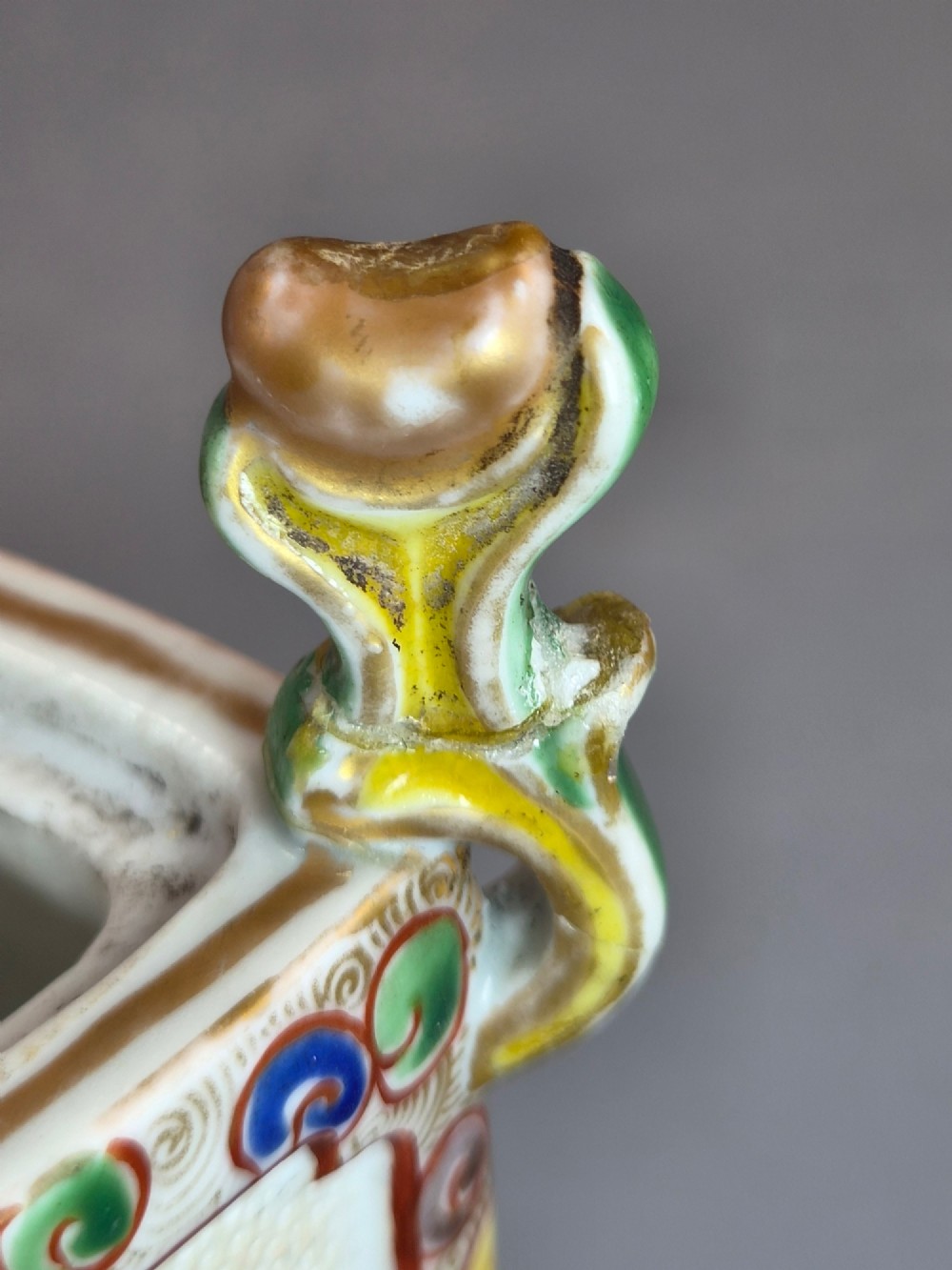 A square Japanese Kutani porcelain incense burner featuring a karashishi lion finial on the lid, hand-painted figural panels, and blue elephant-head legs. View IX