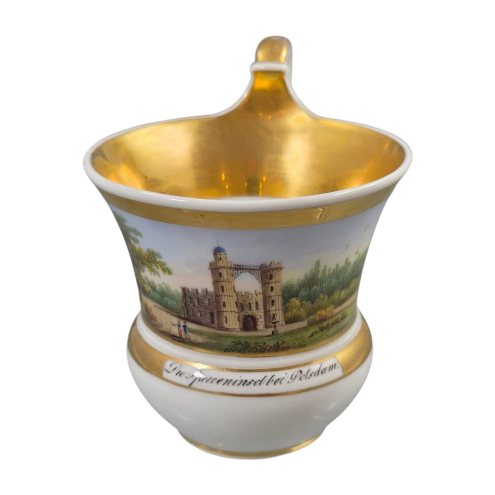 A 19th-century KPM Berlin porcelain cabinet cup with a fully gilded interior, high curved loop handle, and hand-painted topographical view of Peacock Island. View VI