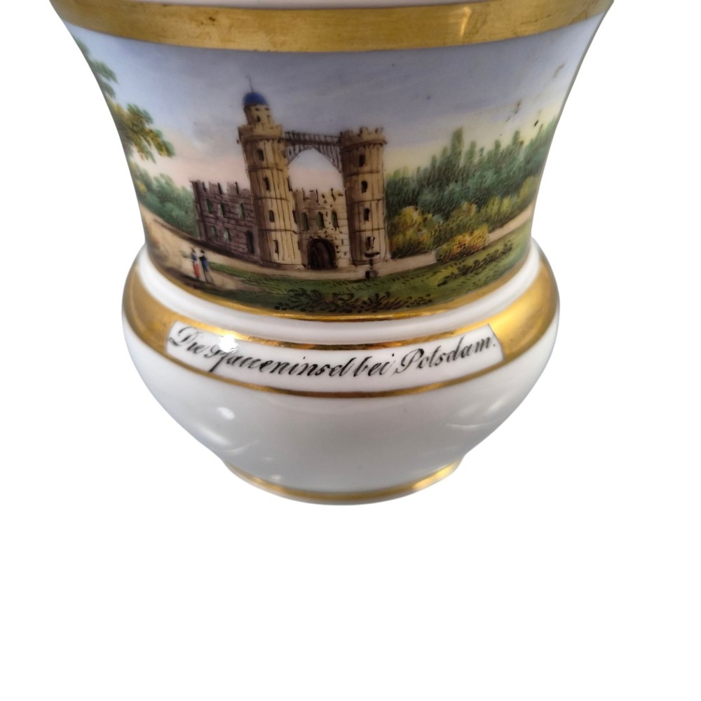 A 19th-century KPM Berlin porcelain cabinet cup with a fully gilded interior, high curved loop handle, and hand-painted topographical view of Peacock Island. View X