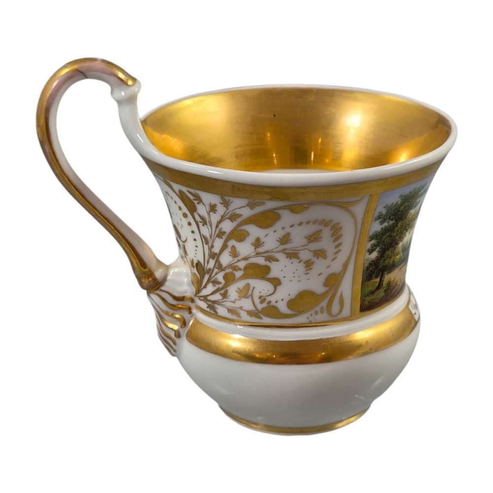 A 19th-century KPM Berlin porcelain cabinet cup with a fully gilded interior, high curved loop handle, and hand-painted topographical view of Peacock Island. View XIII