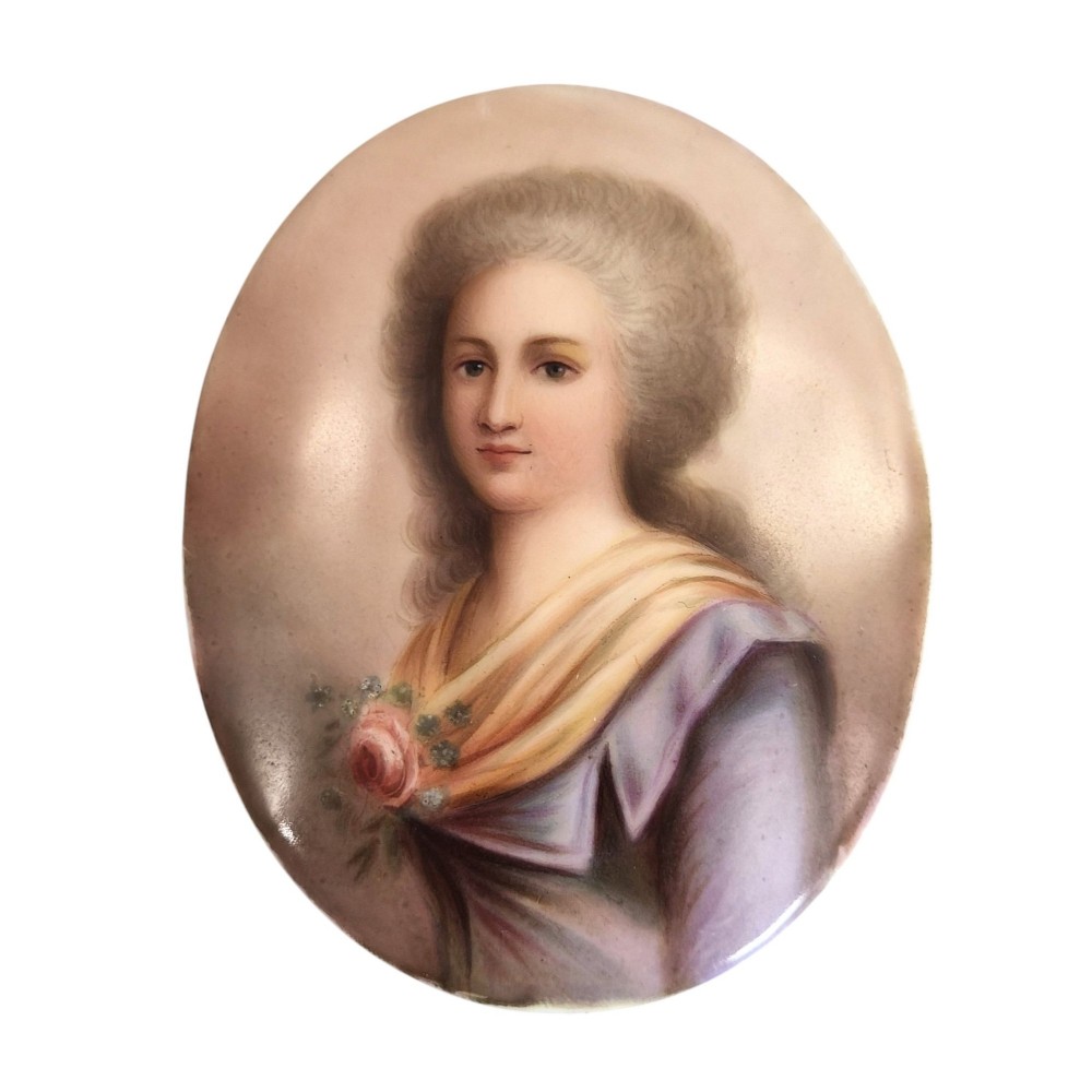 An oval porcelain plaque featuring a hand-painted portrait of a woman with powdered hair wearing a purple dress and yellow shawl with a rose detail. View II