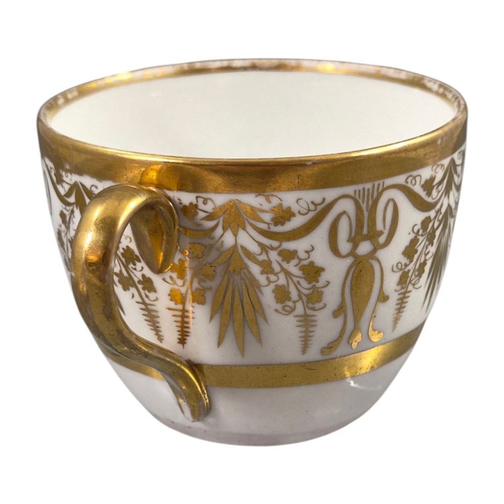 An early nineteenth-century KPM Berlin porcelain cabinet cup and saucer decorated with gilt foliage patterns and hand-painted landscape scenes. View VIII