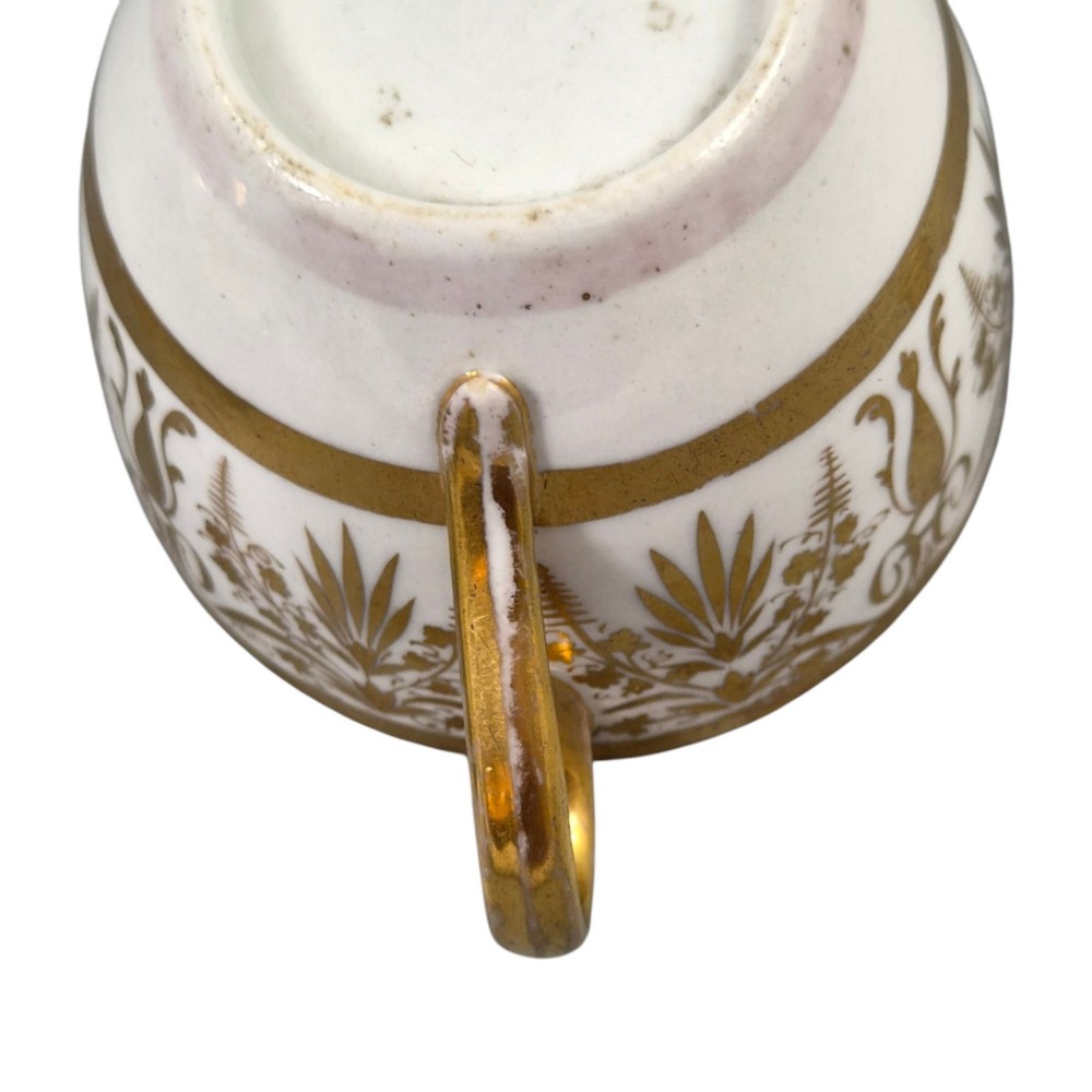 An early nineteenth-century KPM Berlin porcelain cabinet cup and saucer decorated with gilt foliage patterns and hand-painted landscape scenes. View XI