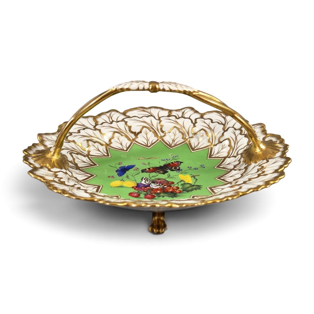 A Regency Flight, Barr and Barr Worcester porcelain handle basket featuring a bright green central reserve decorated with hand-painted butterflies and berries, surrounded by a leaf-moulded rim and gilt handle. View II