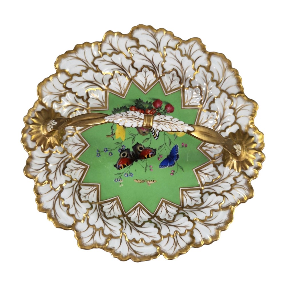 A Regency Flight, Barr and Barr Worcester porcelain handle basket featuring a bright green central reserve decorated with hand-painted butterflies and berries, surrounded by a leaf-moulded rim and gilt handle. View VI