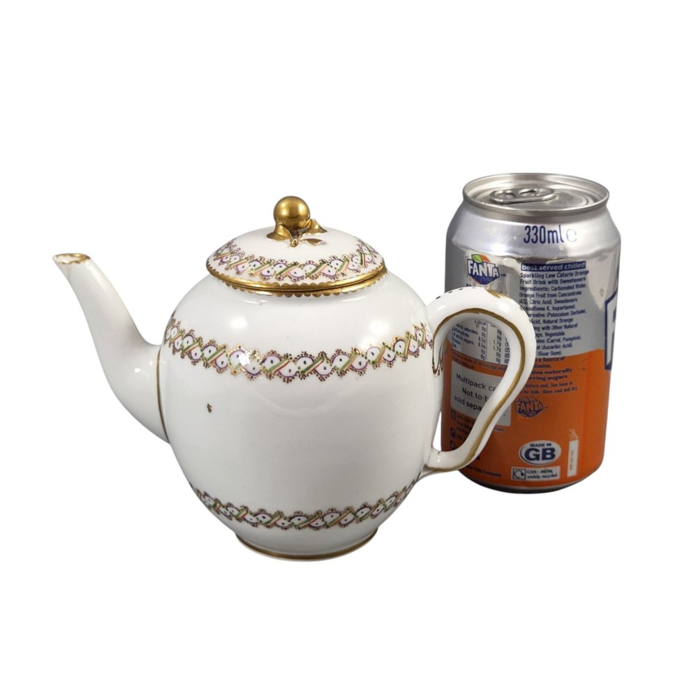 A white Sevres porcelain teapot featuring polychrome geometric enamel borders, gilt trim, a rounded body, and a gilded spherical lid finial. View XIV