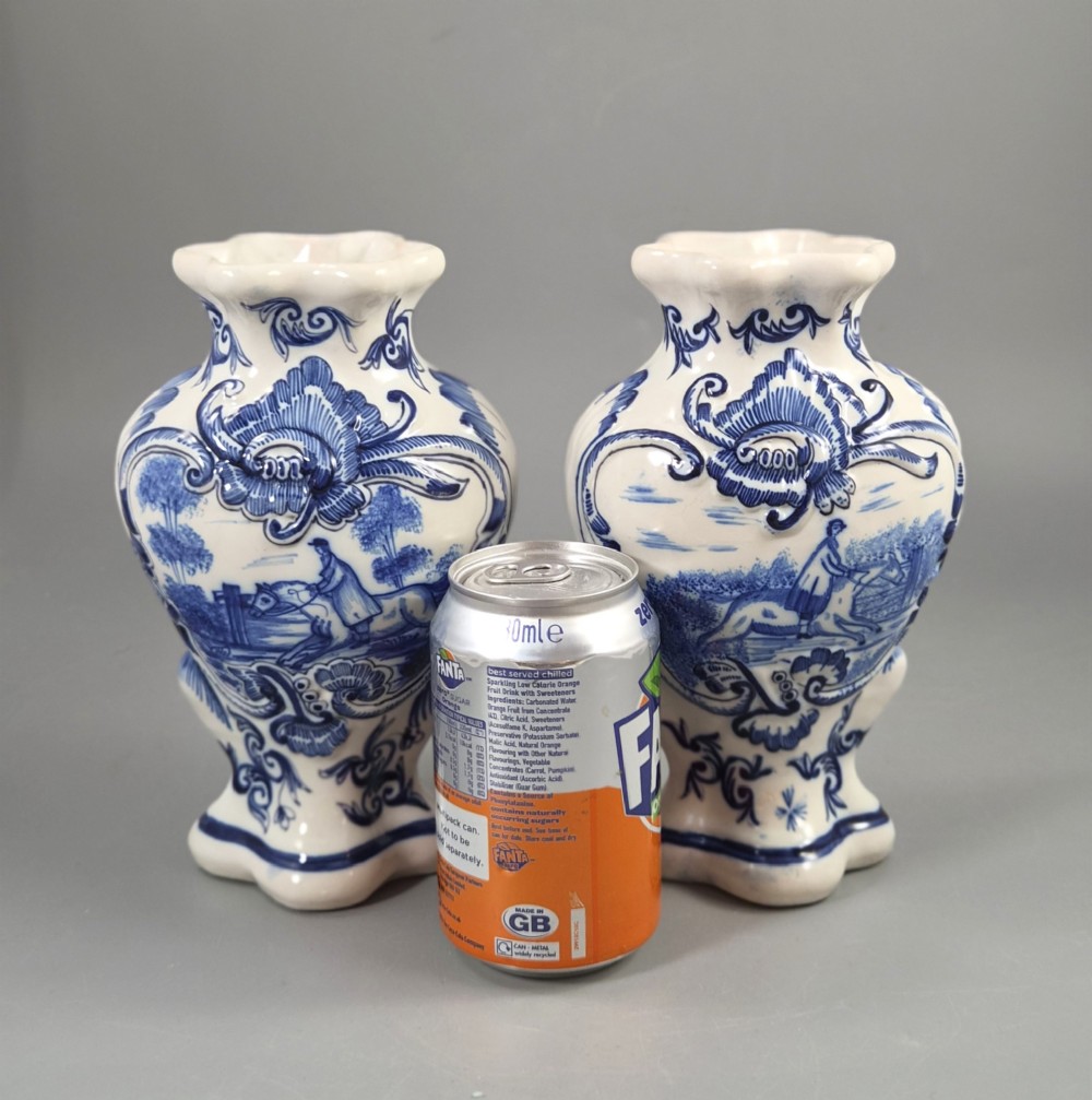 A pair of baluster-shaped blue and white hand-painted French faience vases featuring equestrian scenes and scrollwork motifs. View X