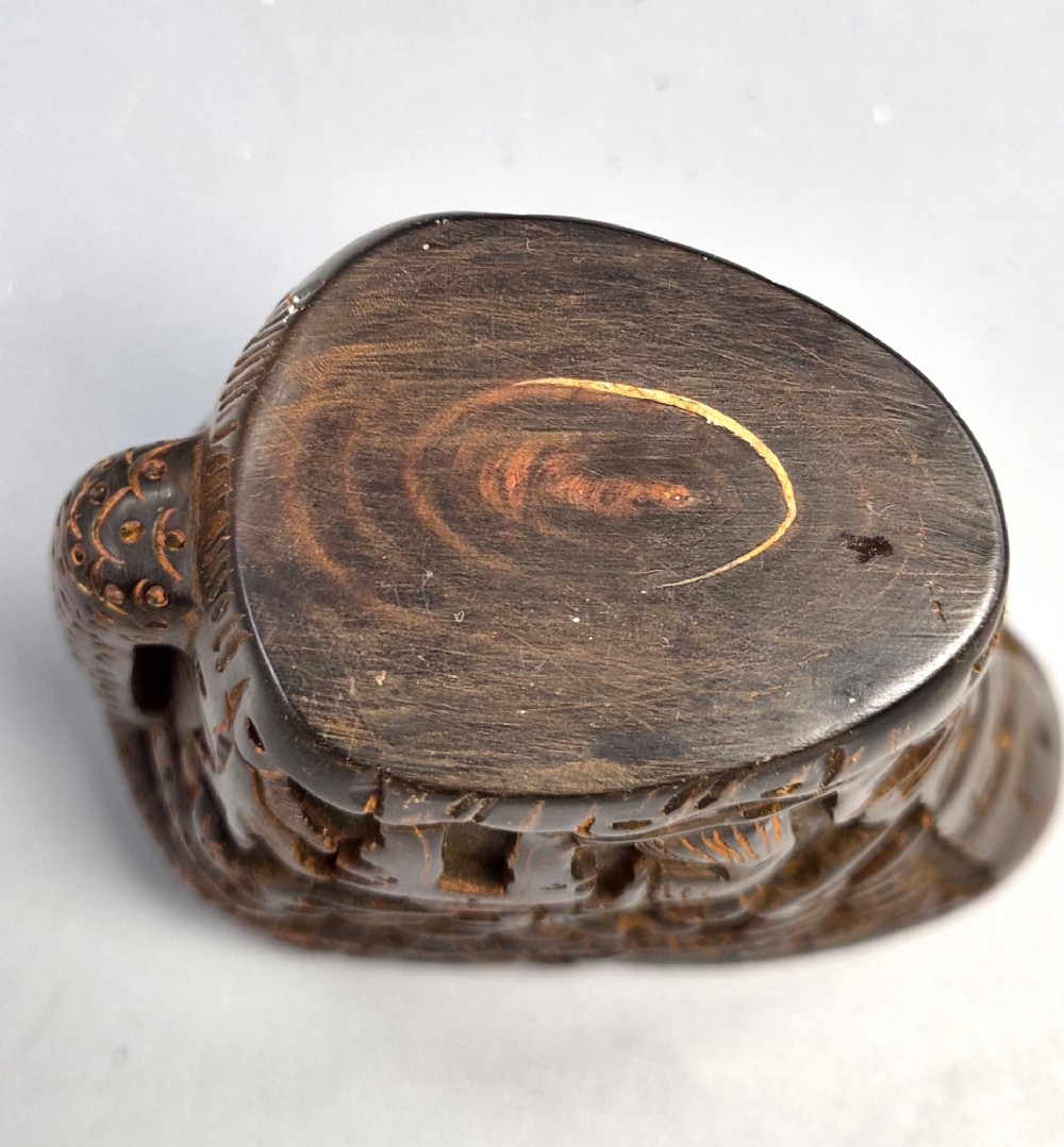A dark brown carved water buffalo horn libation cup featuring relief carvings of immortals standing under pine trees. View VIII