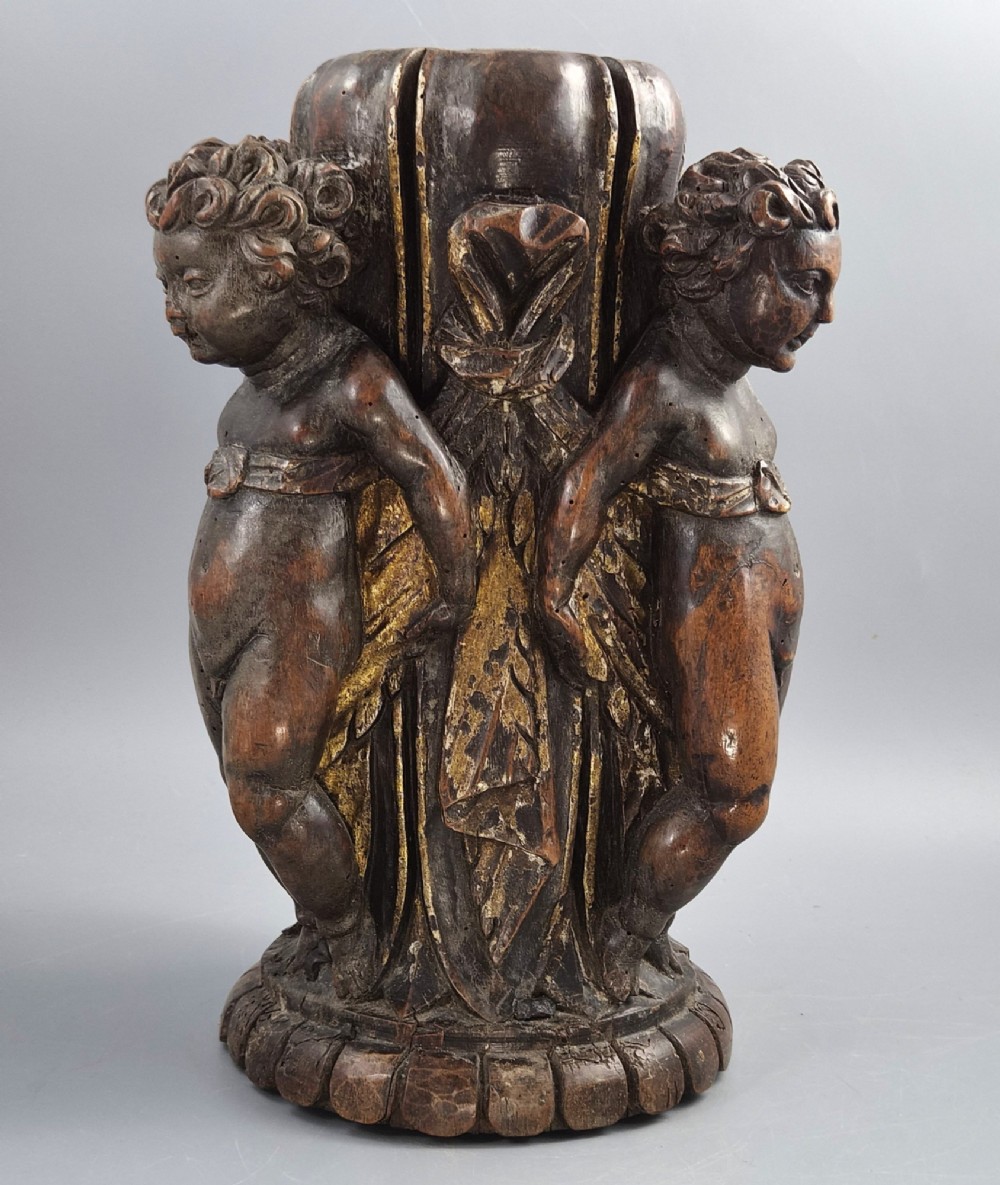 A dark carved walnut Italian Baroque torchiere base featuring three sculpted putti figures standing around a central fluted shaft on a gadrooned circular base. View II
