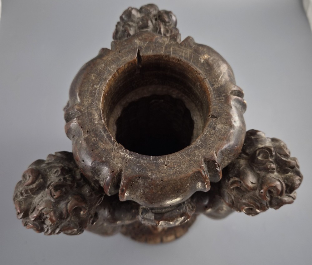 A dark carved walnut Italian Baroque torchiere base featuring three sculpted putti figures standing around a central fluted shaft on a gadrooned circular base. View X