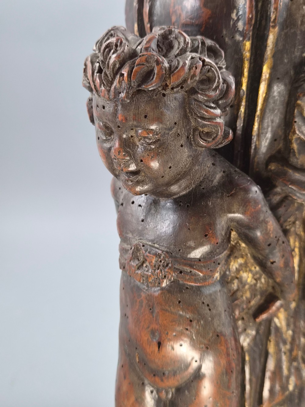 A dark carved walnut Italian Baroque torchiere base featuring three sculpted putti figures standing around a central fluted shaft on a gadrooned circular base. View XIV