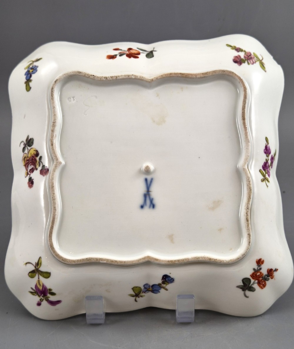 A square shaped Meissen porcelain dish decorated with hand-painted Watteau scenes, floral reserves on a black ground, and gilded scroll borders. View VII