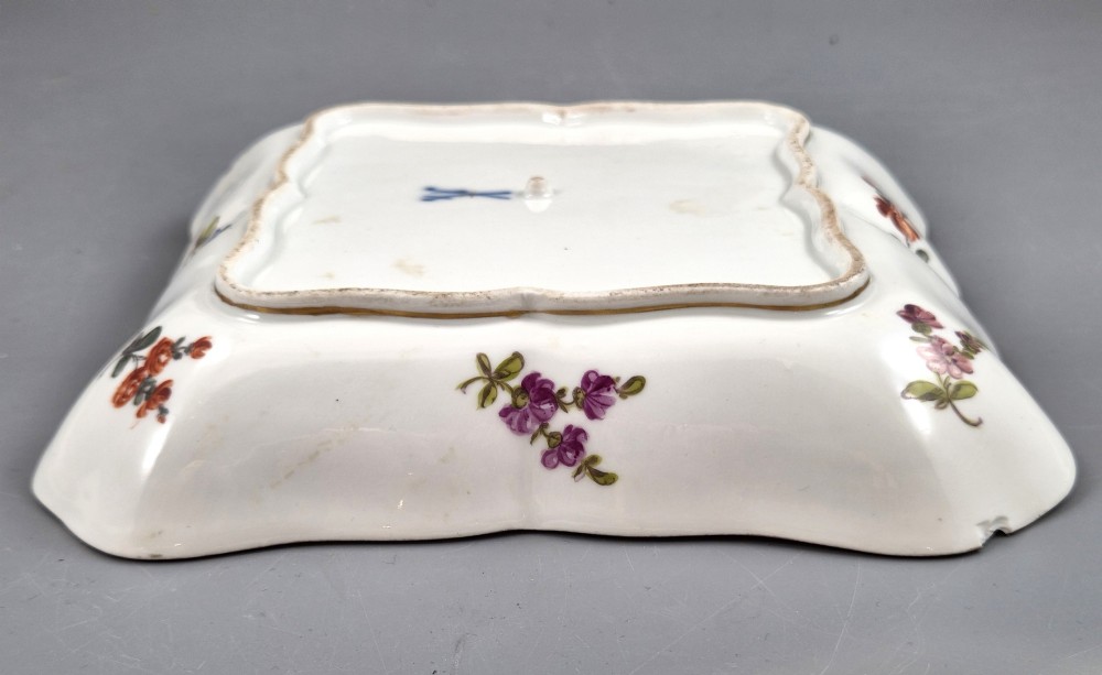 A square shaped Meissen porcelain dish decorated with hand-painted Watteau scenes, floral reserves on a black ground, and gilded scroll borders. View IX