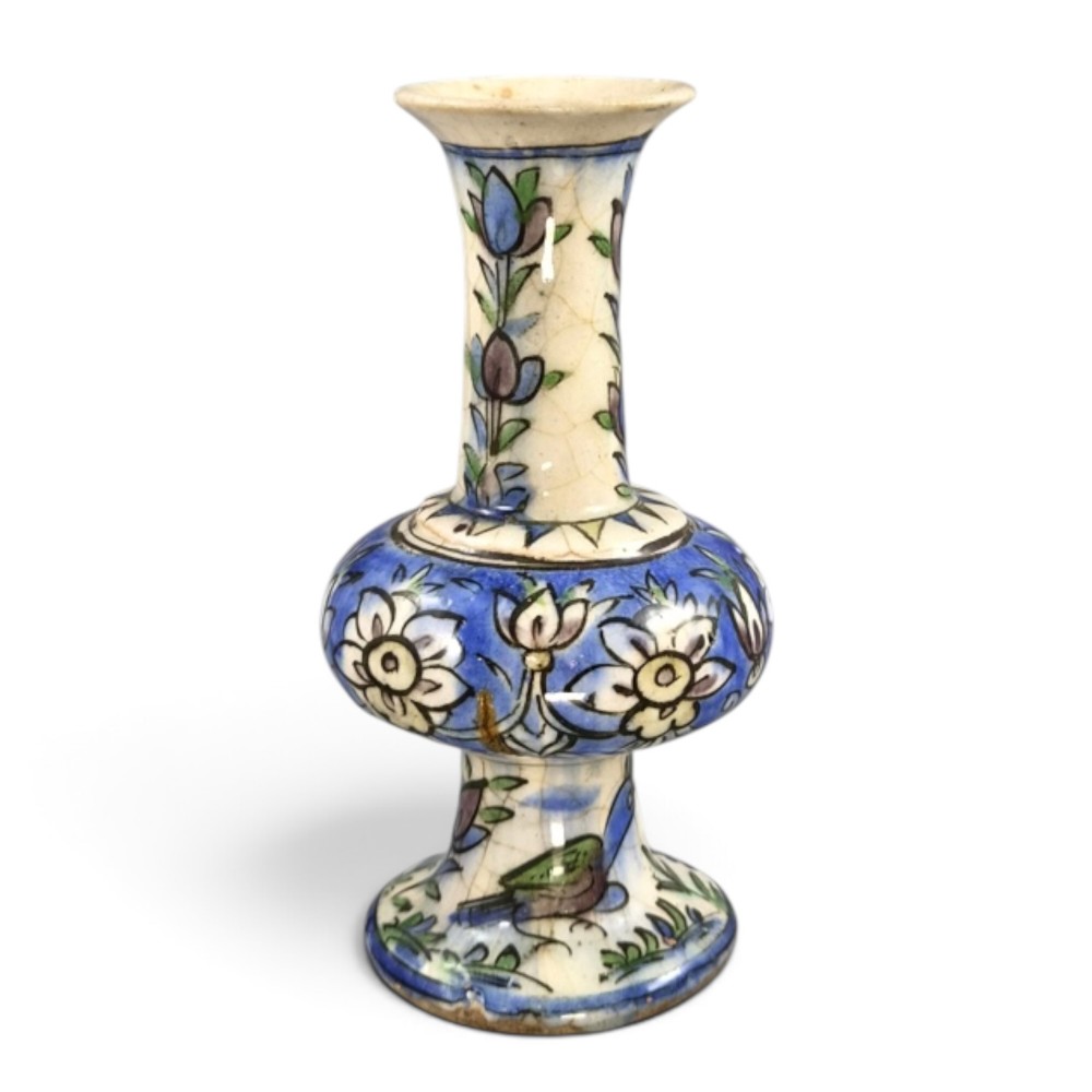 A late Qajar Persian polychrome ceramic vase featuring a central bulbous knop, flared rim, crackle glaze finish, and painted blue and green floral motifs. View II