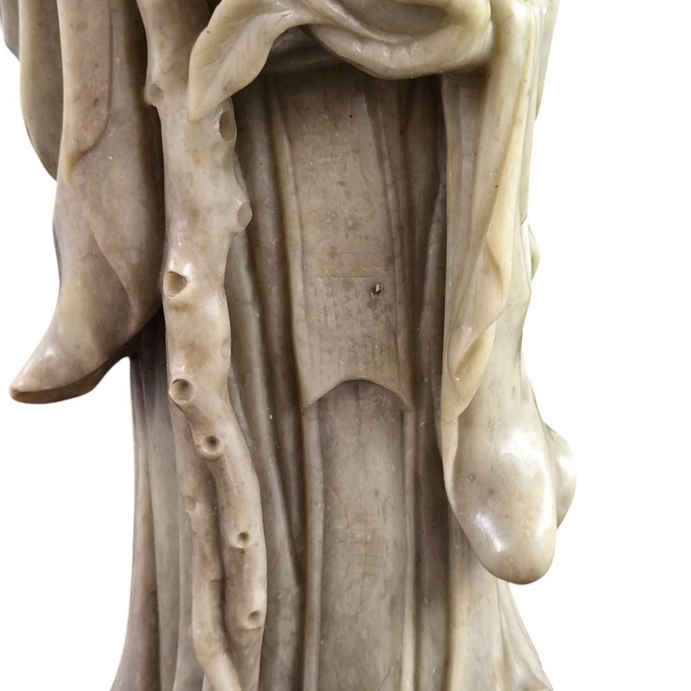 A late 19th-century carved pale soapstone figure of Shoulao holding a peach and staff, standing on a dark stone pierced rockwork base. View XII