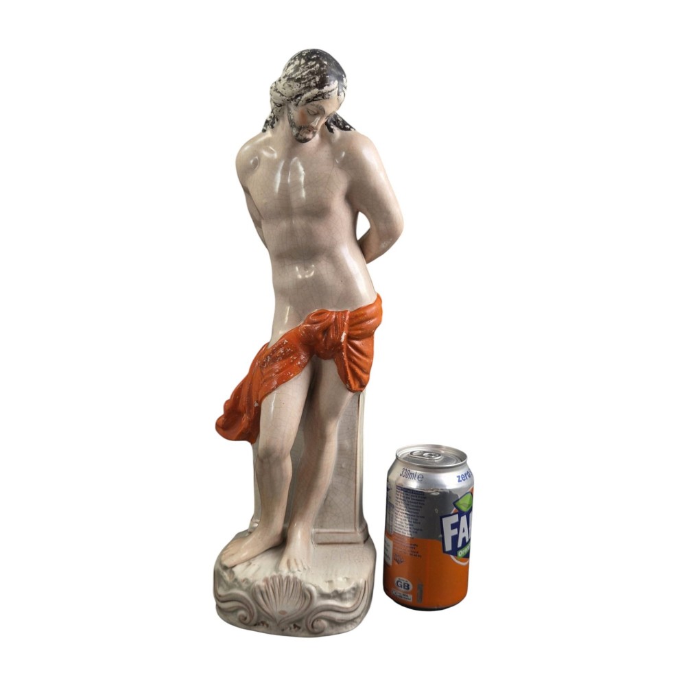 A Victorian earthenware figurine depicting Christ standing at a column draped in a terracotta-coloured cloth on a scrollwork base. View III
