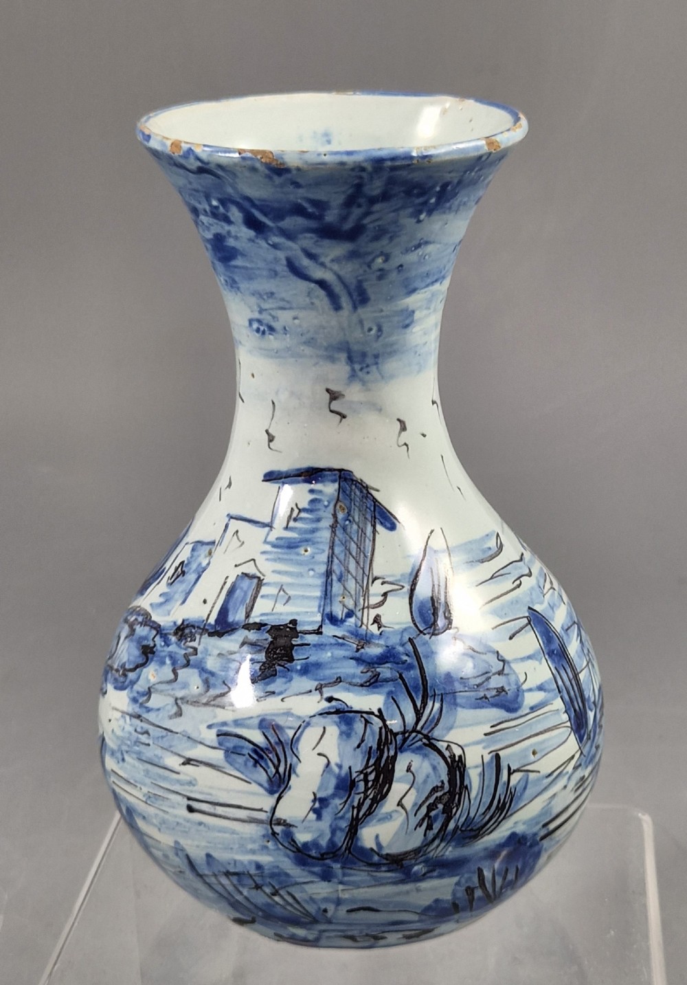 An antique bulbous blue and white maiolica ceramic vase decorated with a hand-painted architectural landscape scene and a flared rim. View V