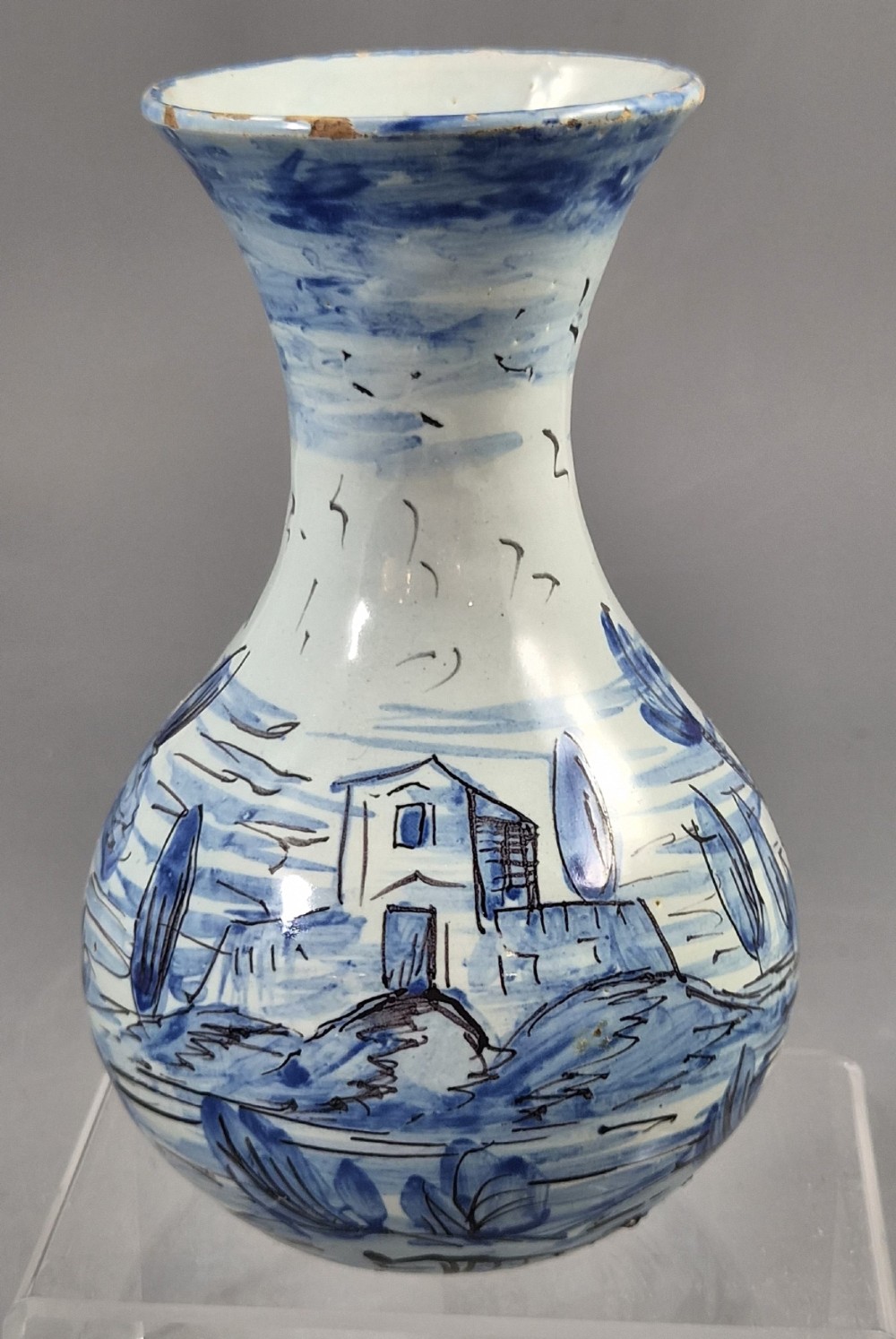 An antique bulbous blue and white maiolica ceramic vase decorated with a hand-painted architectural landscape scene and a flared rim. View VII