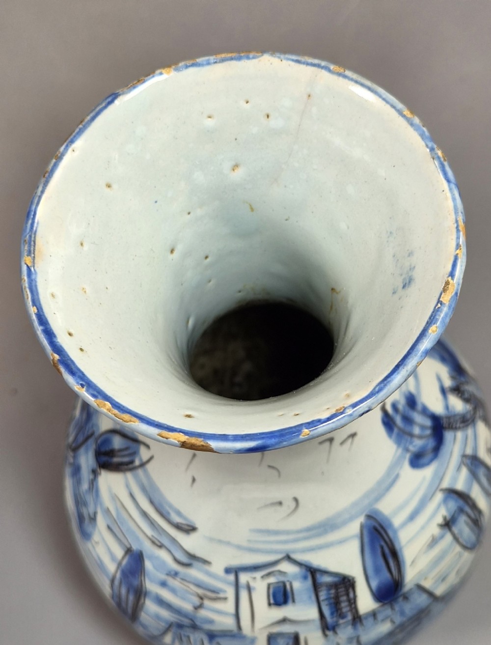 An antique bulbous blue and white maiolica ceramic vase decorated with a hand-painted architectural landscape scene and a flared rim. View VIII