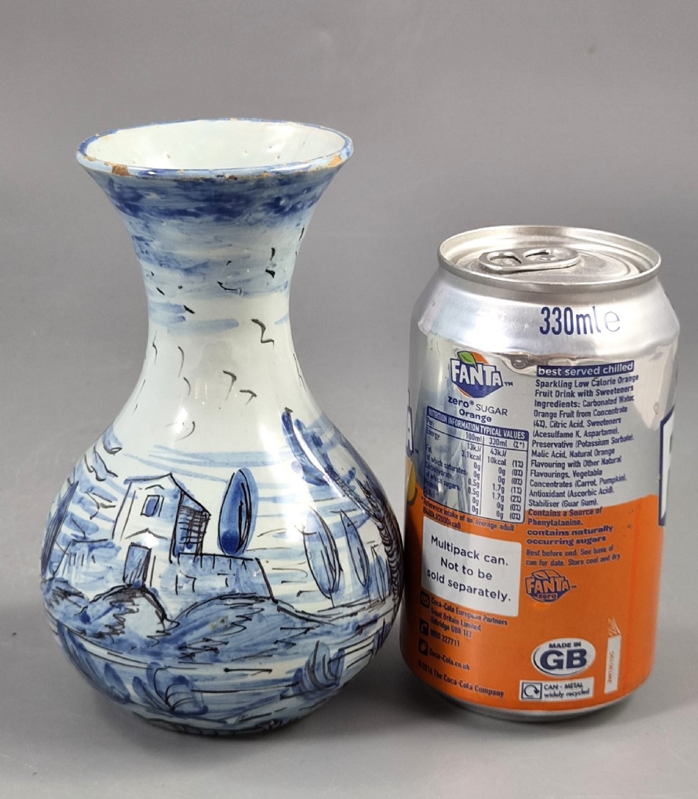 An antique bulbous blue and white maiolica ceramic vase decorated with a hand-painted architectural landscape scene and a flared rim. View XII