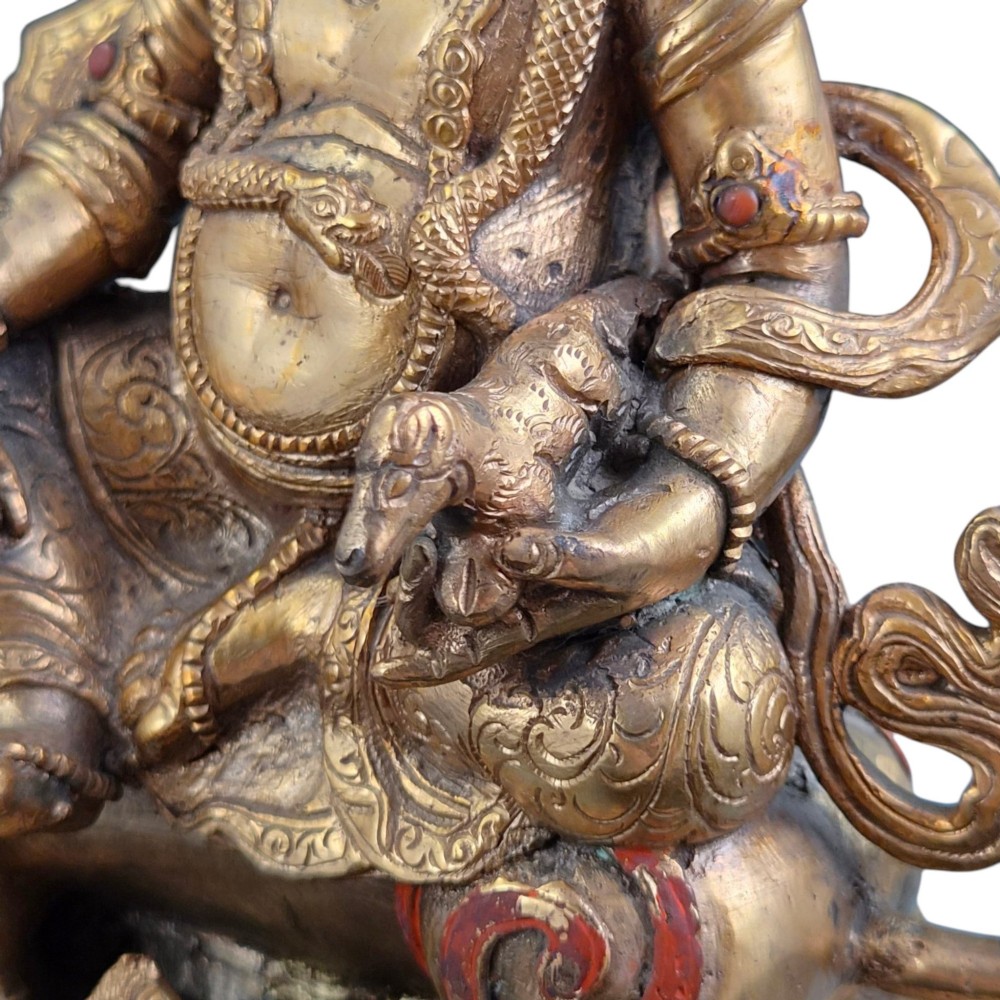 A gilt bronze figure of the deity Jambhala crowned and adorned with jewellery, seated upon a snow lion atop an oval lotus pedestal base with red and blue painted accents. View IX