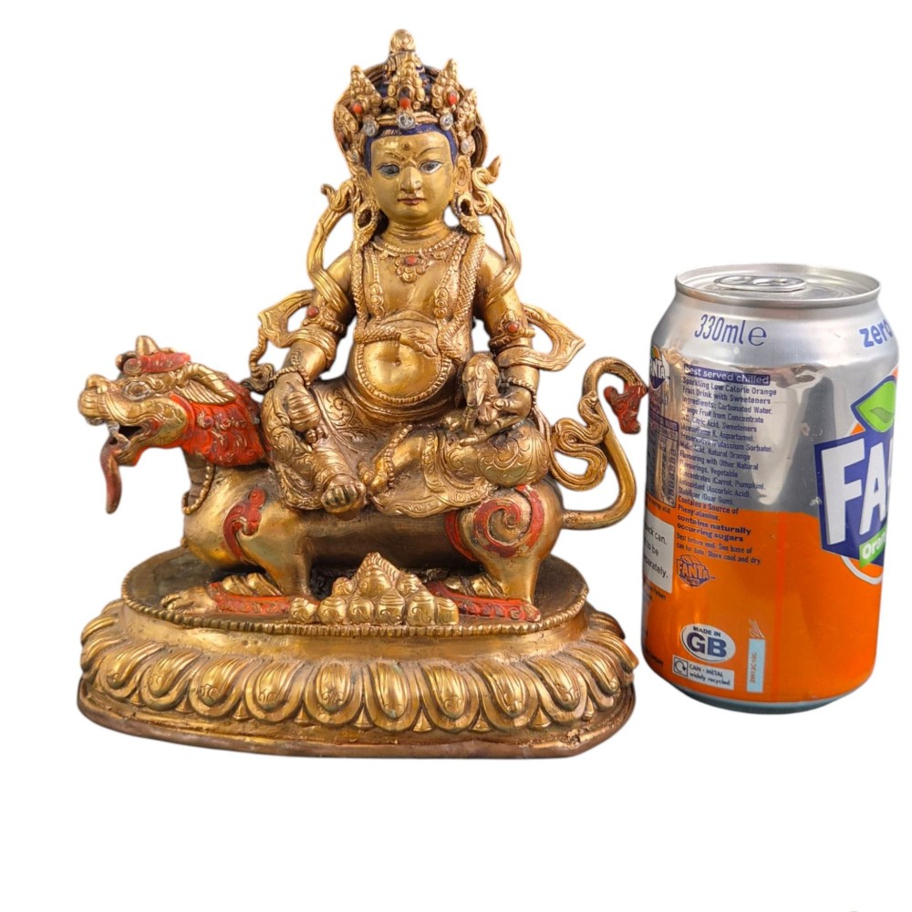 A gilt bronze figure of the deity Jambhala crowned and adorned with jewellery, seated upon a snow lion atop an oval lotus pedestal base with red and blue painted accents. View XII