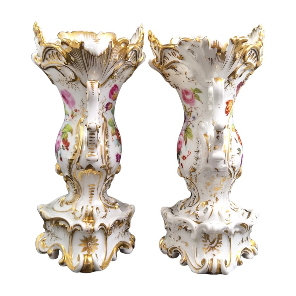 A pair of ornate white and gilded porcelain Rococo vases featuring hand-painted floral bouquets, pierced rims, and scroll handles. View IV